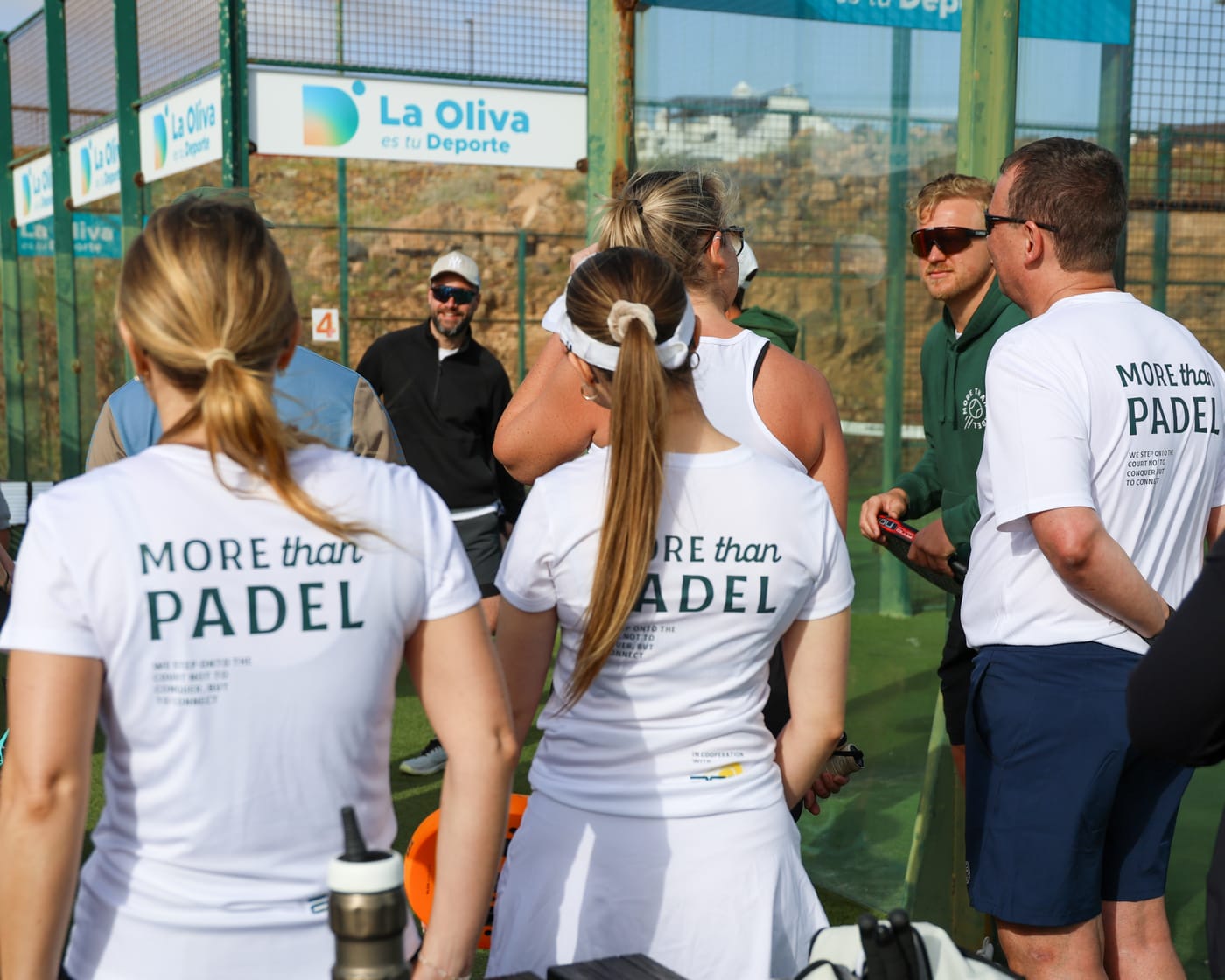 Gruppe in MoreThanPadel-Shirts am Padelcourt