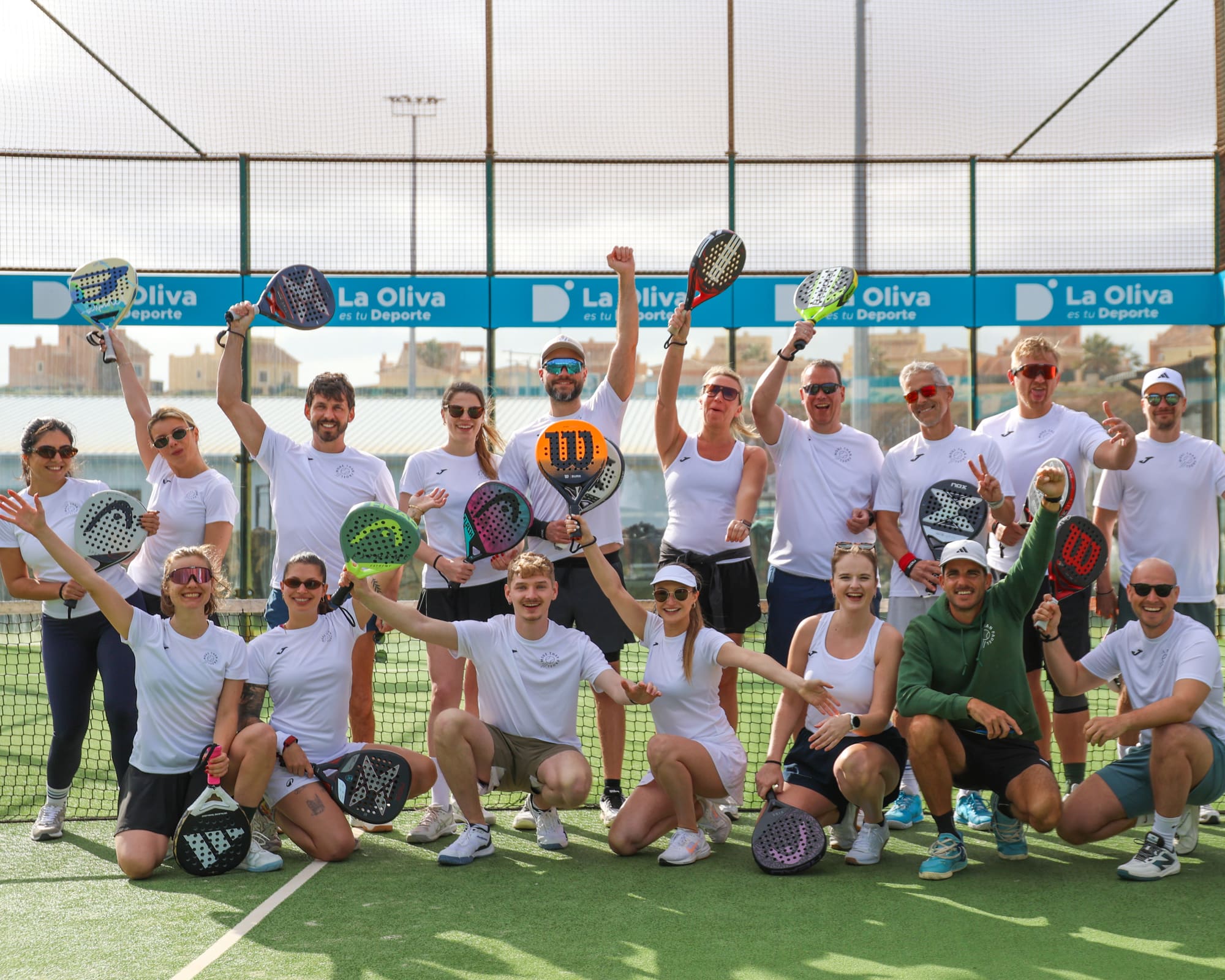 Campgruppe jubelt gemeinsam mit Schlägern auf dem Padelplatz in Corralejo